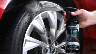 Auto Express products editor Tom Barnard dressing a Skoda Superb's tyre with Diamondbrite Tyre Dressing